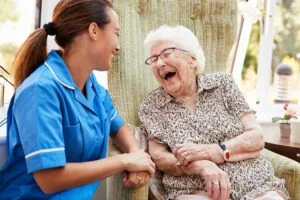 A nurse laughing with an older service user